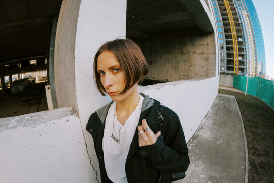 Woman Stands Near Concrete Wall in Urban Construction Site