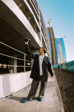 Young Person Records Video at Construction Site in Urban Area