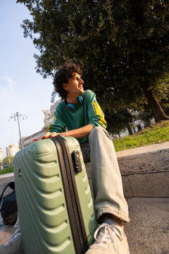 Gen z guy enjoys a moment in Italy with his travel bag