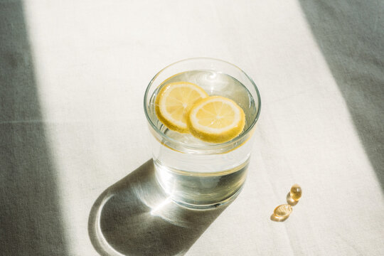 Glass of lemon water and vitamins