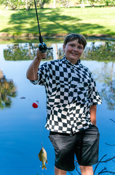  fishing by a calm pond in a lush green park.