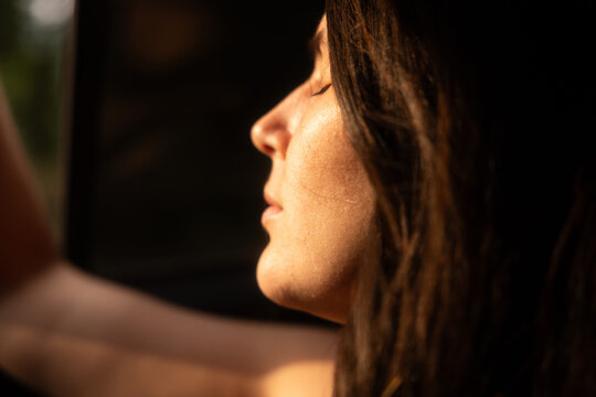 Woman's profile in warm golden hour sunlight