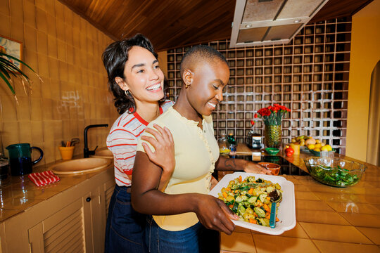 Happy partners preparing healthy meal together in kitchen