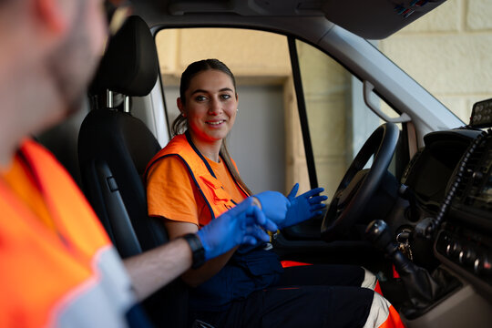 Paramedic wearing gloves preparing for emergency service in ambulance