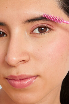 Woman grooming eyebrows with brush for personal beauty care