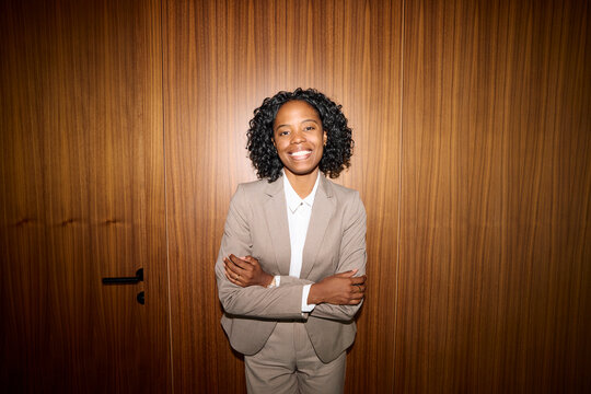 Elegant woman pose for a photo against wooden wall