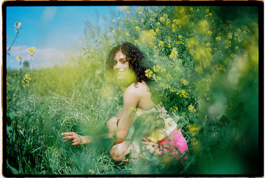 Smiling woman in a blooming flower field