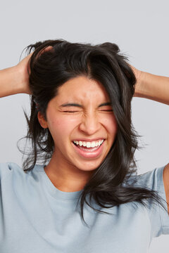 Woman laughing with eyes closed touching hair