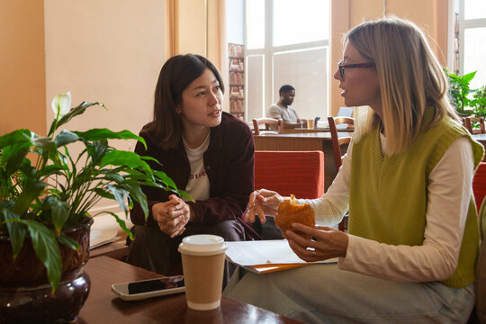 Diverse students conversing and studying in a university library