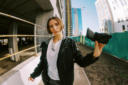Person Holds Camera While Standing at Construction Site in Daylight