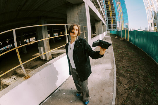 Person Holds Camera While Standing at Construction Site in Daylight