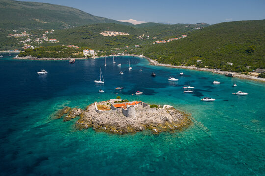 Coastal View of a Fortress and Boats in Clear Blue Water