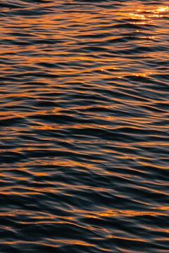 Sunlight on ocean water ripples at sunset