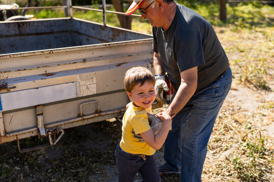 Grandfather and grandson enjoying time together outdoors helping