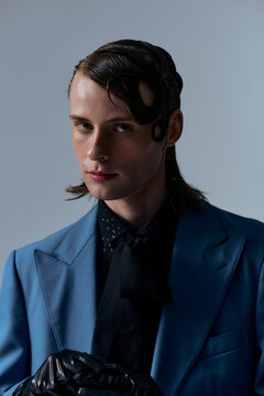 Stylish young man poses confidently in a modern studio setting