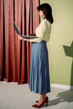Businesswoman Standing and Working on Laptop in Modern Interior