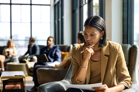 BusinessWoman Analyzes Documents in office Lounge