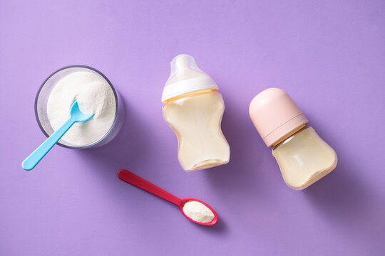 Baby formula powder and bottles on a purple background