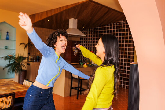 Joyful woman laughing and embracing with happiness at home