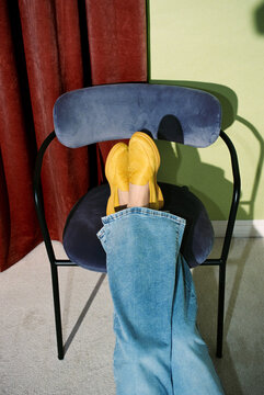 Relaxed Legs in Yellow Shoes Resting on Velvet Chair