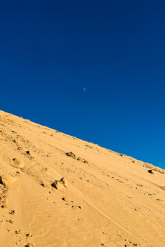 Moon Rising Behind a Steep Sand Dune