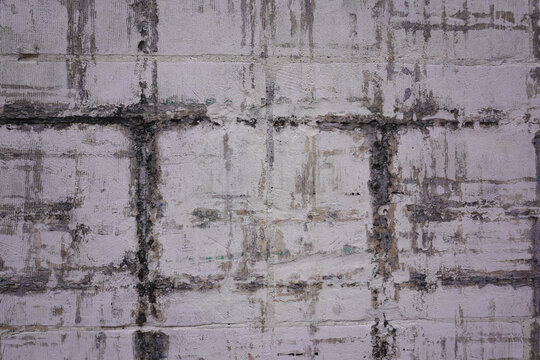 Grungy concrete wall texture with worn industrial grid patterns in urban France