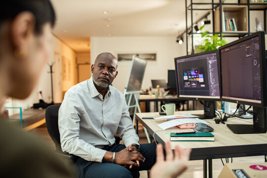 Coworkers discuss a design project in a modern office