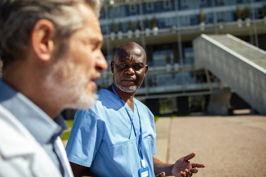 Two healthcare professionals discussing outside a hospital