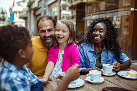 Smiling family enjoying coffee at outdoor cafe