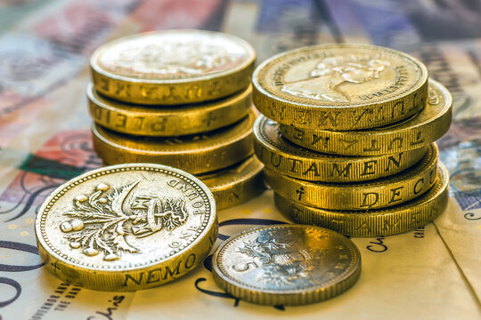 British Pound Coins against a background of British assorted bank notes