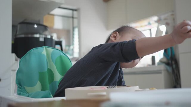 A cheerful baby sitting in a high chair, exploring different snacks with curiosity in a cozy kitchen setting. Bright colors and soft light enhance the playful atmosphere, perfect for capturing joyful 