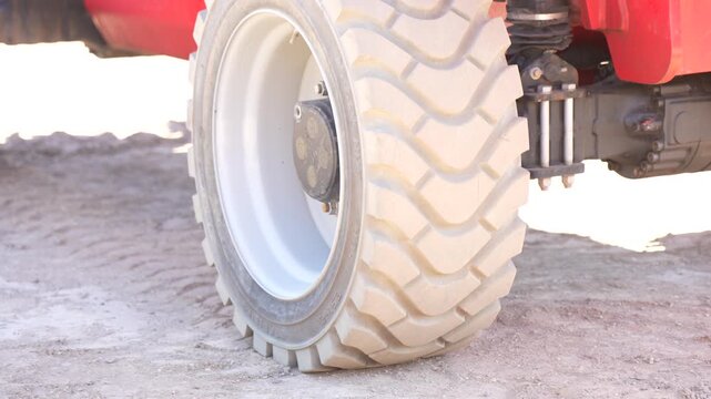 Large heavy machinery rubber tire tread on dirt ground, professional civil engineering equipment maintenance and industrial construction infrastructure business