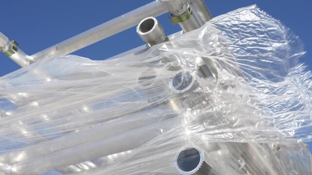Aluminum truss construction parts wrapped in protective plastic stretch film, stage building event gear warehouse storage and equipment logistics industry
