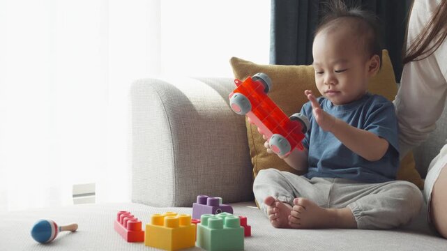 A child joyfully explores colorful building blocks and toys in a cozy indoor setting, promoting creativity and learning through play.