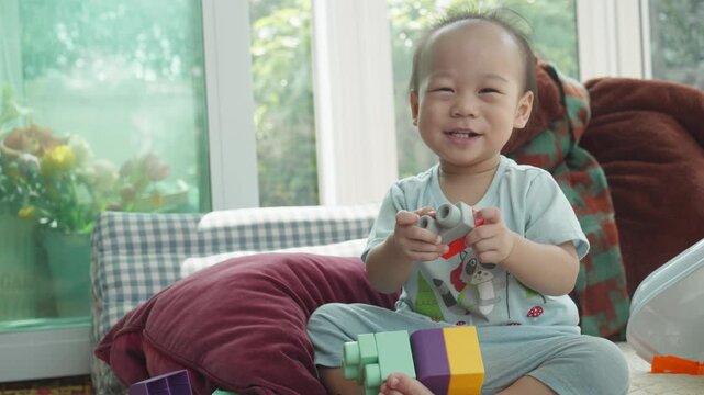 A joyful child engages with colorful building blocks, enhancing creativity and motor skills. The bright setting and playful atmosphere contribute to a delightful learning experience for the young one.