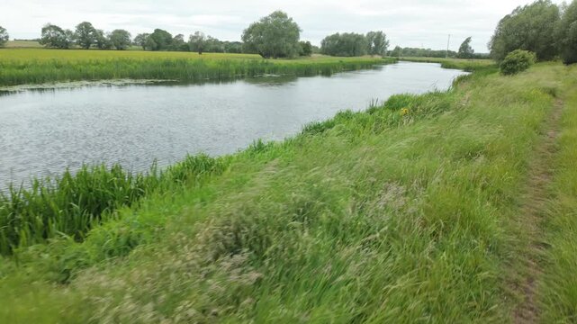 Water Newton, Cambridgeshire, England, UK - June 01 2026: Gimbal mounted sequence point of view, walking on a public footpath by the River Nene just outside Water Newton, Peterborough.