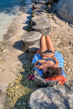 Young Caucasian woman relaxing on Lombok beach lying on tropical sand