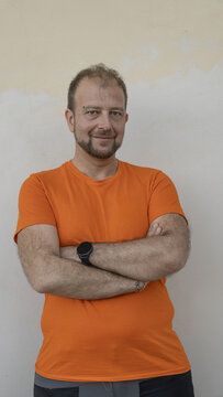 Confident worker portrait standing in front of a textured wall wearing industrial work clothes