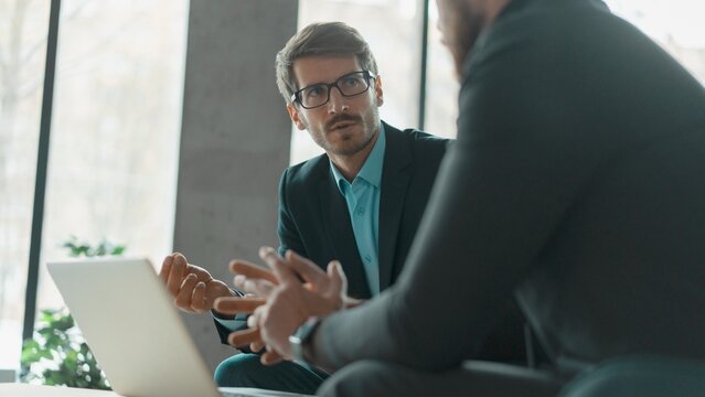 Businessmen discussing deal, sharing startup ideas, business partners negotiations or job interview in modern office