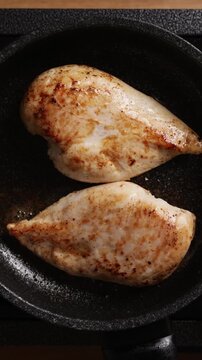 Searing Chicken Breasts In Frying Pan Vertical Top View Close Up