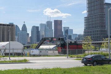 Naklejka premium heavy machinery at Cherry Street Yard with view of Toronto's cityscape