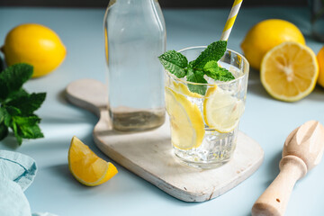 Lemon infused water with mint in glass beside bottle, healthy hydration and wellness concept, copy space © Inga