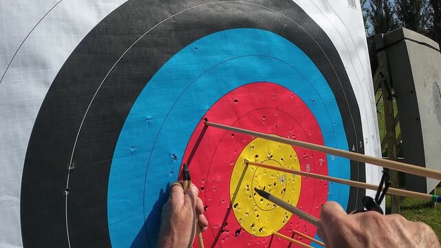 Archer retrieving arrows from a colorful target