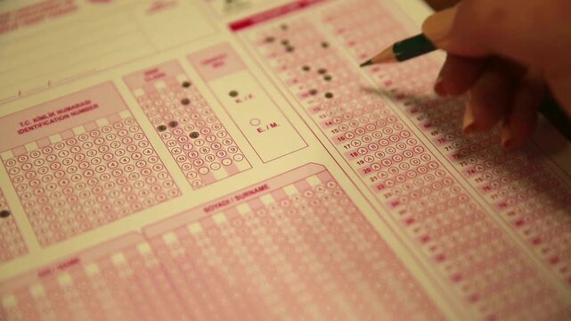 Student Filling Out OMR Multiple Choice Exam Bubble Sheet with Pencil