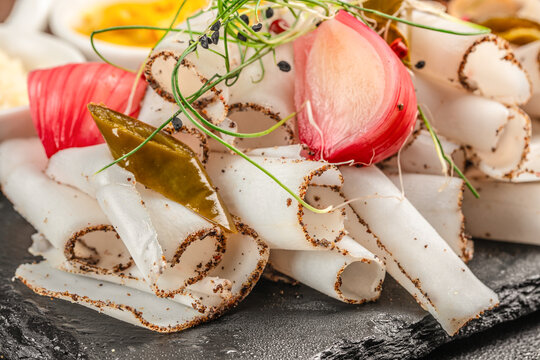 Traditional cured pork lard appetizer with pickled onion and herbs