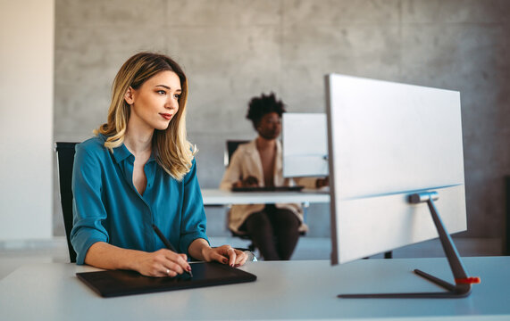 Young happy successful business woman working in corporate office