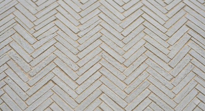 Light gray herringbone brick paving pattern close up