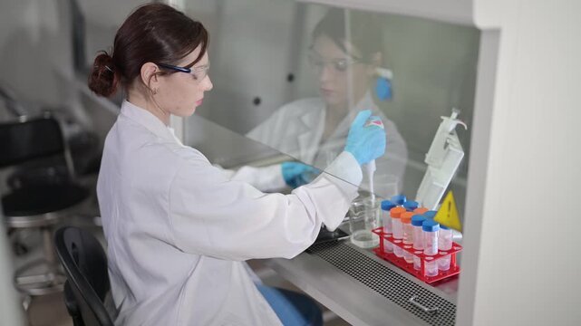 Lab technician conducts experiments in a laboratory, testing samples and recording results