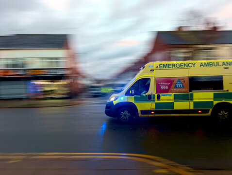 Leicester, England, UK - 24 November 2025: Ambulance, emergency vehicle, NHS paramedic van speeding on UK city street, motion blur panning shot