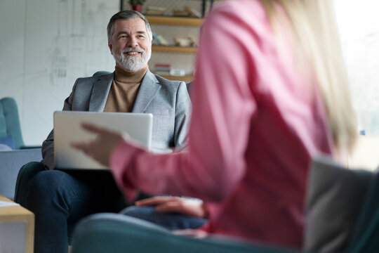 Happy mature businessman professional bank manager or financial advisor consulting woman client